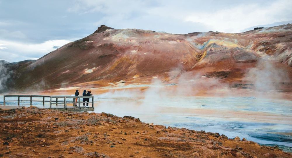 Picture of red-ish Mars alike landscape with geothermal steam and boiling water.