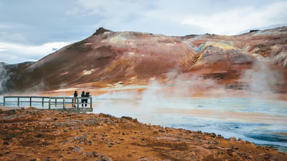 Picture of red-ish Mars alike landscape with geothermal steam and boiling water.