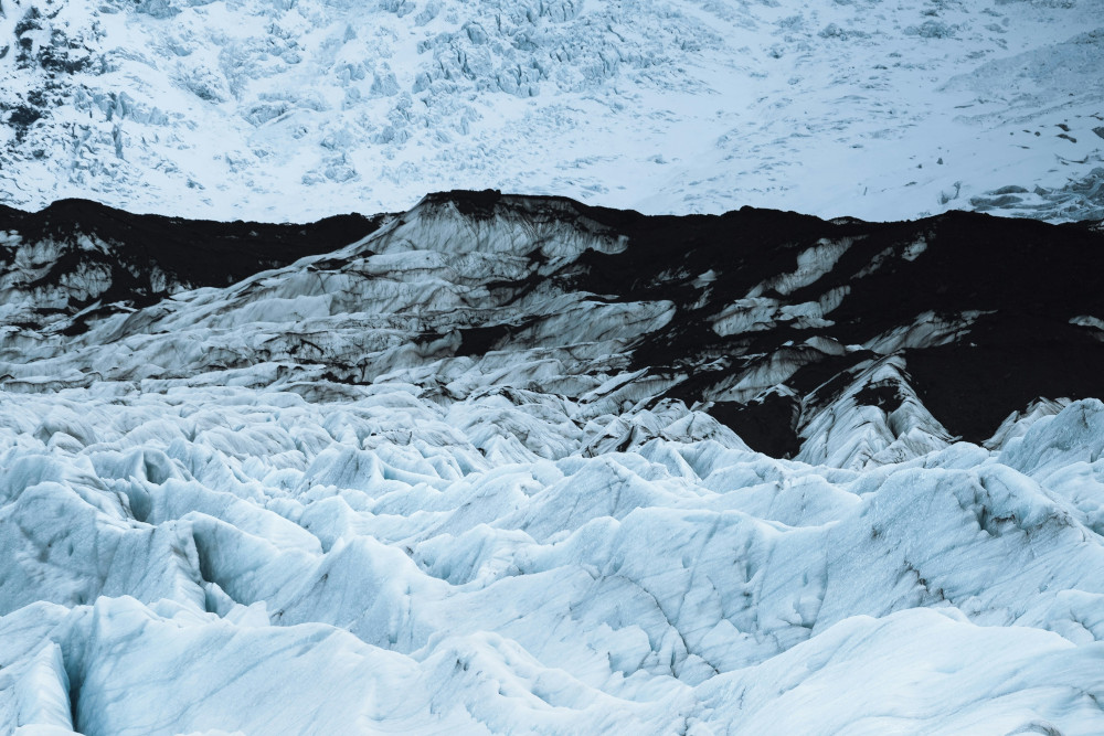 Black ash hill, middle on a white glacier.