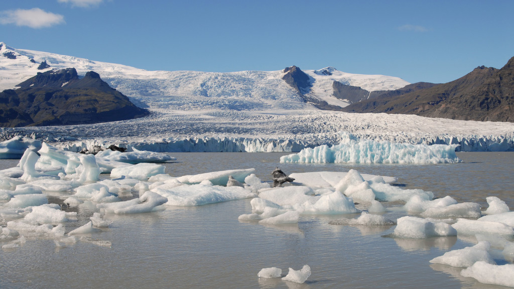 View over Fjallsárlón glacial lagoon with Fjallsjökull glacier and mountains in the back.