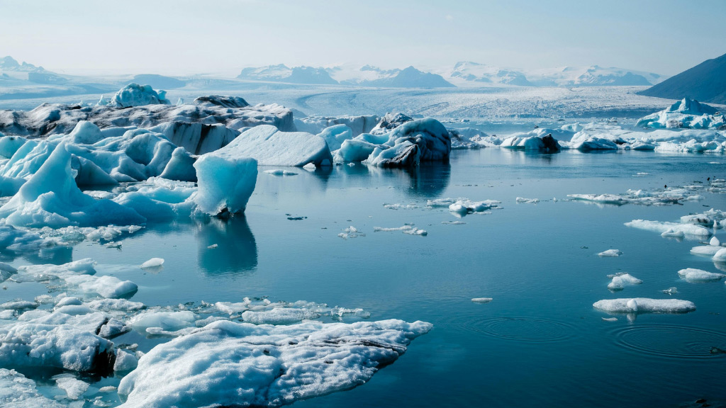 Why-Iceland’s-Ice-Caves-are-Changing_-the-Impact-of-Melting-Glaciers---Pic-2 A view of floating icebergs on Jökulsárlón glacier lagoon with Breiðamerkurjökull glacier in the back.